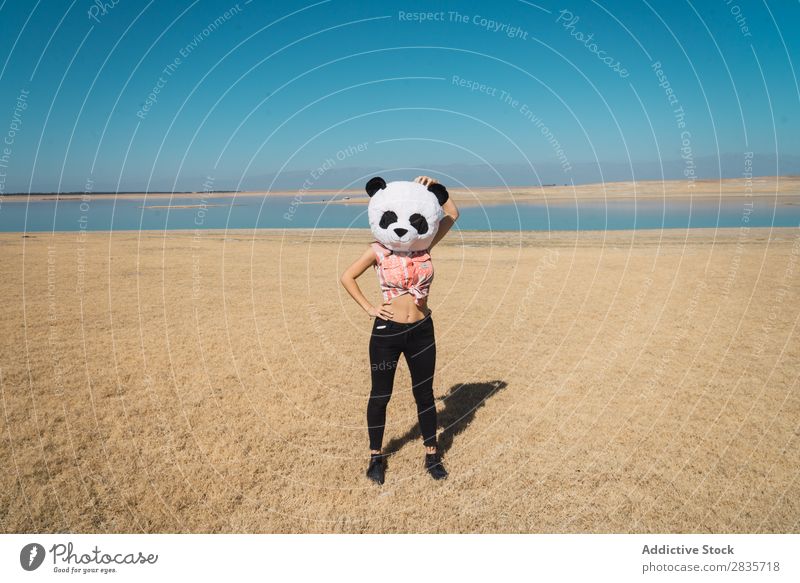 Frau mit Pandahut, die auf der Natur posiert. Hut Kreativität Kostüm reisend anhaben Spaß haben Landschaft Erholung Fernweh künstlich Stil Pose