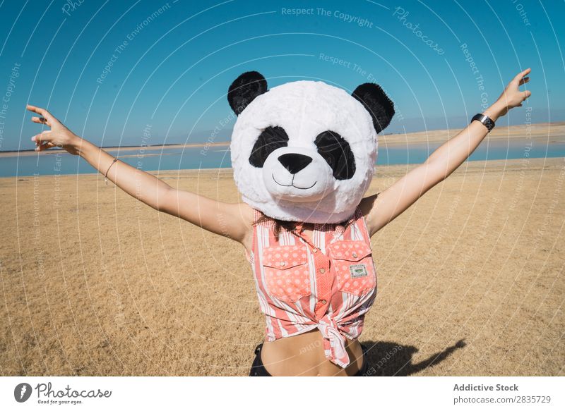 Frau mit Pandahut, die auf der Natur posiert. Hut Kreativität Kostüm reisend anhaben Spaß haben Landschaft Erholung Fernweh künstlich Stil Pose