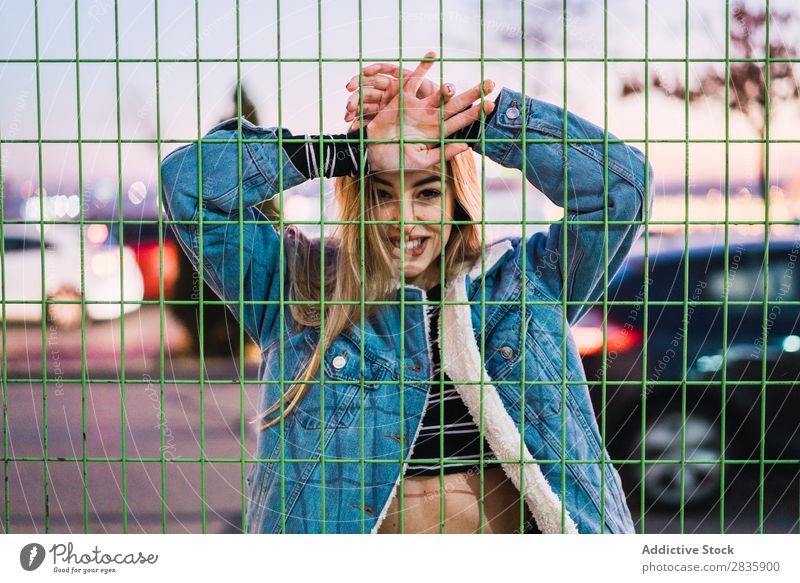 Verführerisches junges Model, das hinter dem Netz posiert. Frau aufreizend Rebell Stil selbstbewußt Menschliches Gesicht verführerisch Tennisnetz genießen