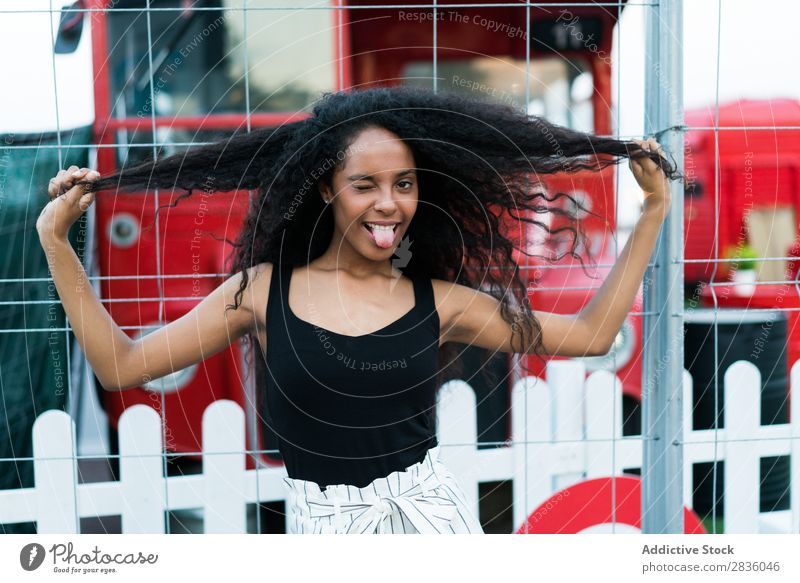 Verspielte Frau blinzelt. hübsch Jugendliche Porträt Zwinkern ausspannen Gesichter machen Grimassen schneiden Blick in die Kamera schwarz Afrikanisch Großstadt