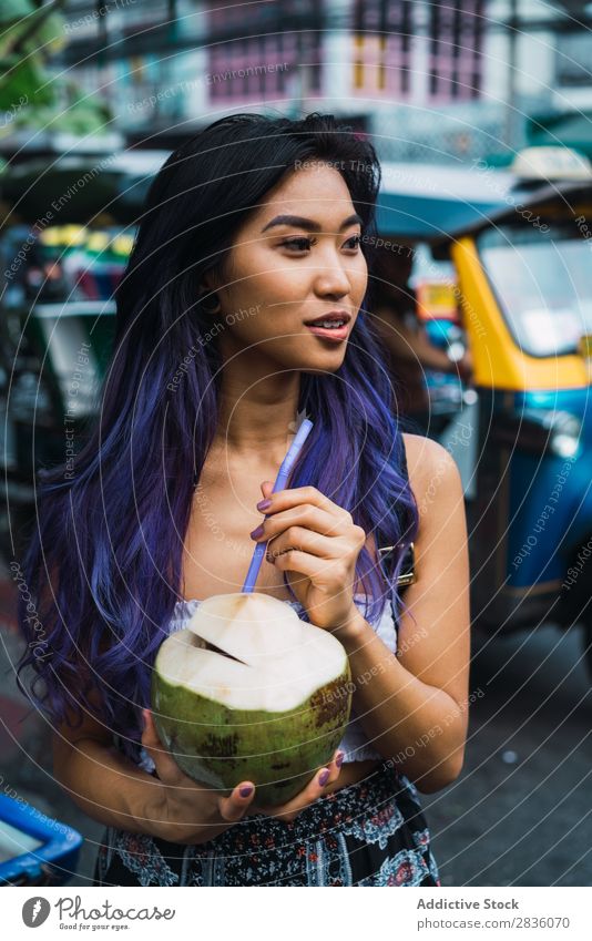 Asiatin mit Kokosnuss Frau hübsch Straße Jugendliche schön Porträt trinken Trinkhalm Behaarung purpur asiatisch Östlich Mode attraktiv Großstadt Mensch