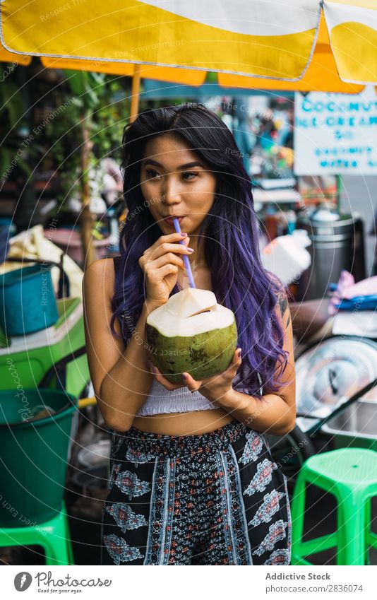 Asiatin trinkt aus Kokosnuss Frau hübsch Straße Jugendliche schön Porträt trinken Trinkhalm Behaarung purpur asiatisch Östlich Mode attraktiv Großstadt Mensch