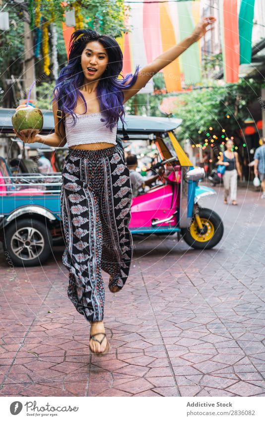 Junge Frau mit Kokosnussgetränk auf der Straße hübsch Jugendliche schön Porträt stehen trinken Trinkhalm Behaarung purpur asiatisch Östlich Mode attraktiv