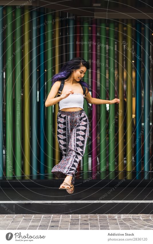 Junge Frau, die auf bunten Säulen posiert. hübsch Straße Jugendliche schön mehrfarbig Porträt Behaarung purpur asiatisch Östlich Mode attraktiv Großstadt Mensch