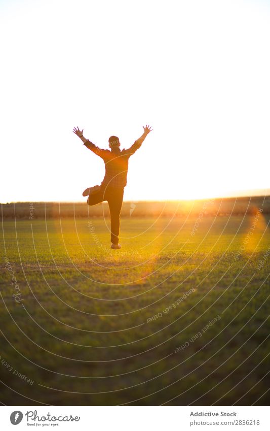Mann springt auf sonniges Feld Freude springen Fröhlichkeit Sommer Freiheit Natur Aktion Mensch Jugendliche Wiese Gras Energie grün Lifestyle frei rennen