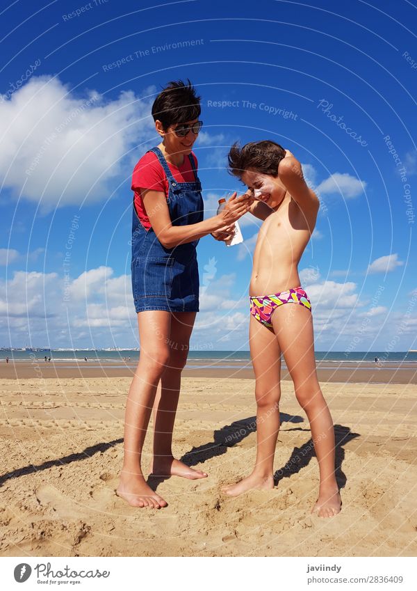 Mutter wirft Sonnenschutzmittel auf ihre kleine Tochter an einem tropischen Strand Lifestyle Freude Glück schön Sahne Freizeit & Hobby Ferien & Urlaub & Reisen