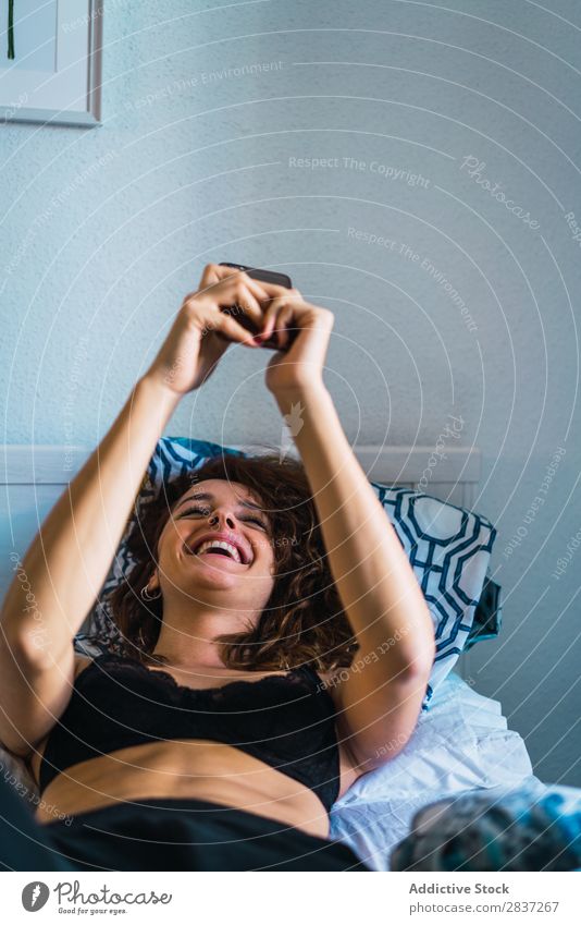 Hübsche Frau im Bett mit Smartphone heimwärts Frühstück Schlafzimmer Behaarung Unterwäsche hübsch Jugendliche Körperhaltung Erholung Porträt schön Lifestyle