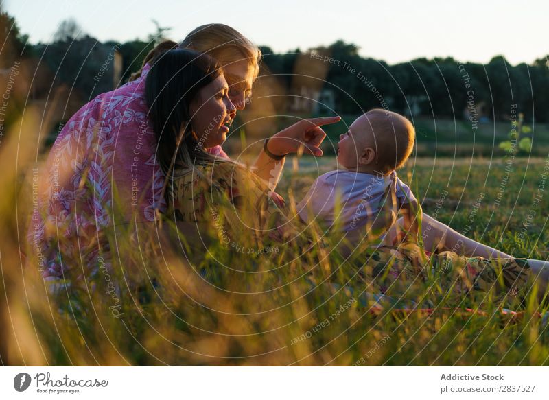 Glückliche lesbische Familie mit Kind Mutter Park Rasen grün Sonnenstrahlen Mensch Frau Fröhlichkeit Sommer Lifestyle Liebe gleichgeschlechtliche Eltern