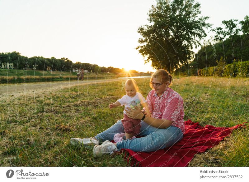 Frau mit Kind auf dem Rasen Mutter Park grün Sonnenstrahlen Glück Mensch Fröhlichkeit Sommer Lifestyle Liebe gleichgeschlechtliche Eltern Homosexualität Paar