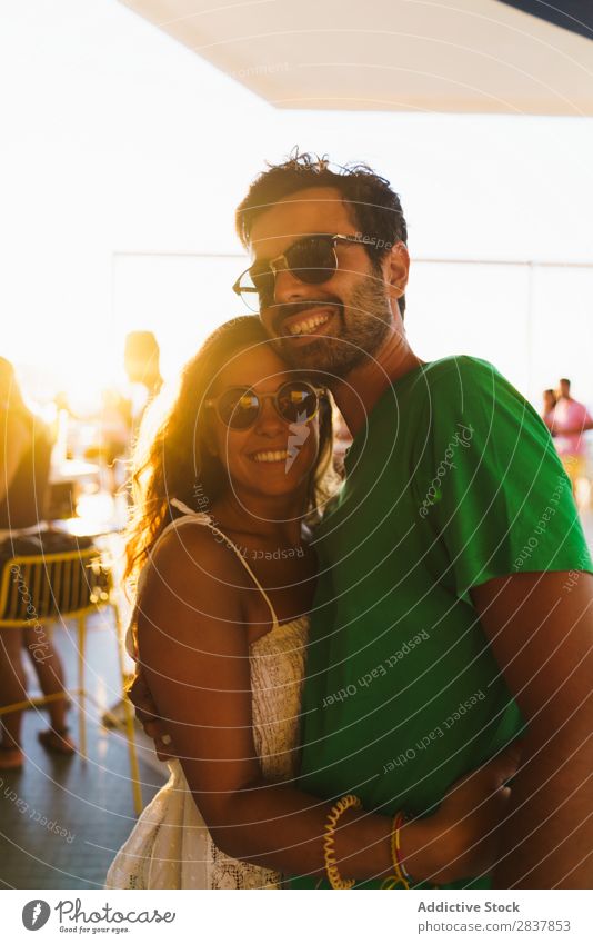 Fröhliche Menschen, die sich im Sonnenlicht umarmen. Paar umarmend Körperhaltung Fröhlichkeit urwüchsig Zusammensein Veranstaltung romantisch Sommer