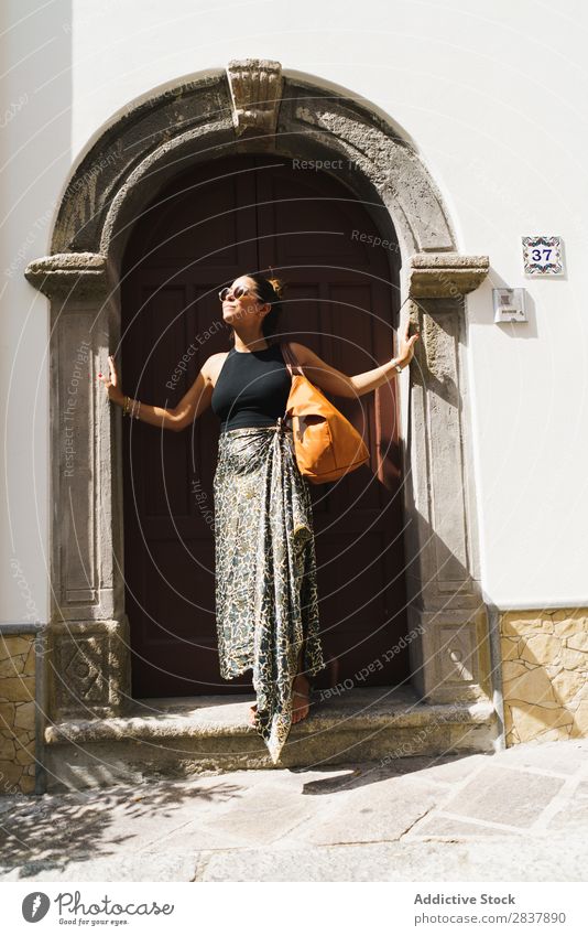 Stilvoller Reisender, der in der Türöffnung posiert. Frau reisend Straße genießen romantisch Fröhlichkeit genießend Genuss Sommer Erholung Großstadt Stadt