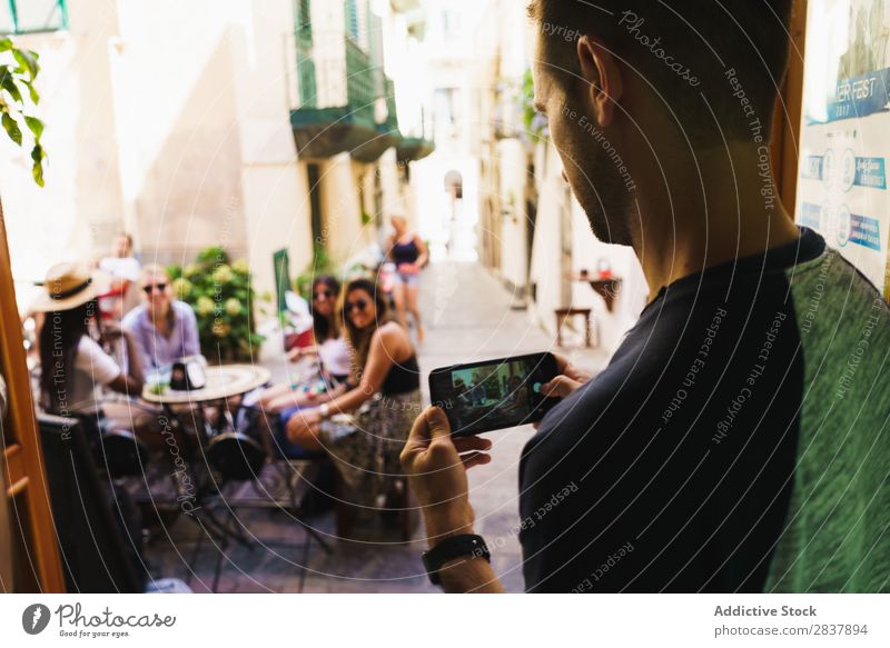 Mann beim Fotografieren von Freunden Mensch Freundschaft fotografierend Straße Café reisend Sommer Erinnerung PDA Restaurant Grafik u. Illustration