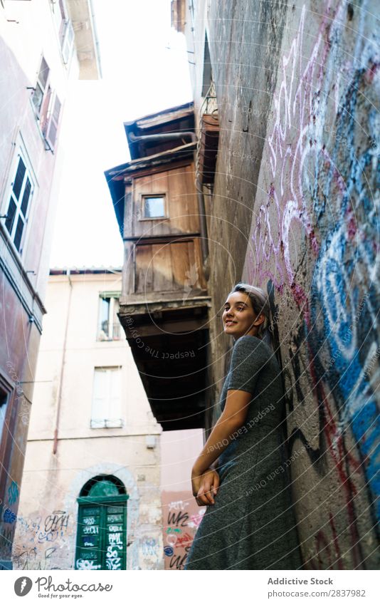 Lächelnde Frau in der Gasse Graffiti Wand hübsch Straße Lifestyle heiter ruhig Erholung blond laufen lieblich attraktiv Dame Großstadt Jugendliche Mensch