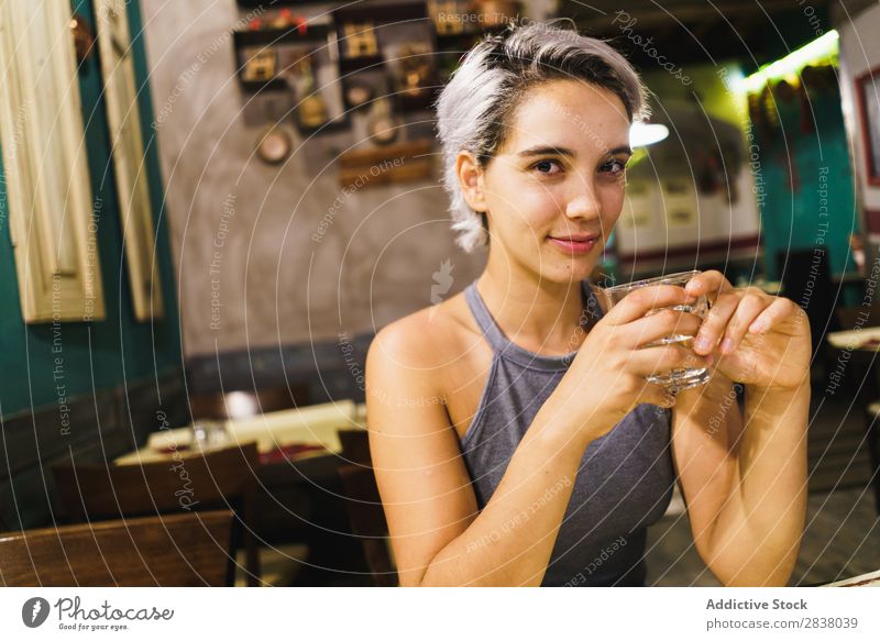 Junge Frau mit Getränk in der Bar Körperhaltung Feste & Feiern lässig trinken Erholung Innenarchitektur Pub Beautyfotografie Glas horizontal Restaurant Stil