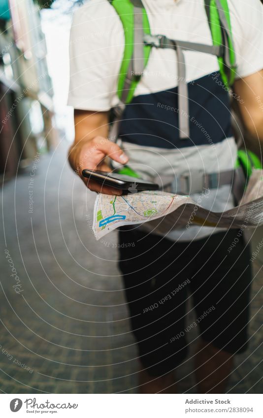 Mann mit Telefon und Karte beschneiden Rucksacktourismus Tourismus PDA Landkarte Gps Großstadt Orientierung Richtung Backpacker Stadt Apparatur Aktion Internet