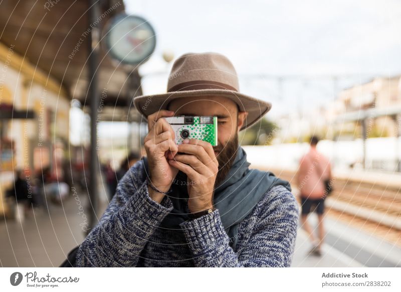 Mann macht Aufnahmen mit einer kleinen Kamera. Fotograf lässig Tourismus Eisenbahn Station Ferien & Urlaub & Reisen Fotokamera Tourist Reisender zielen