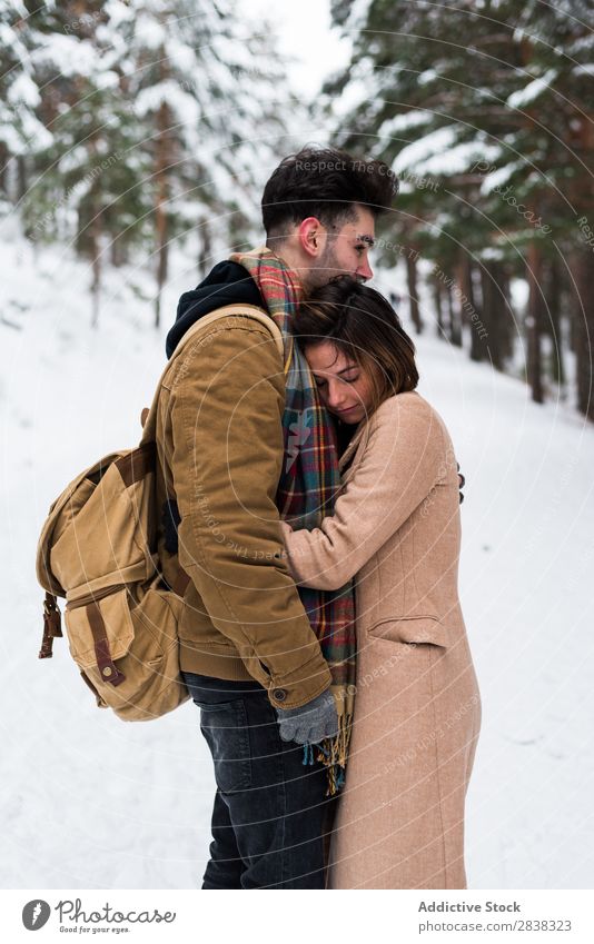 Ein Paar, das sich im Wald umarmt. umarmend Winter Zusammensein Partnerschaft schön romantisch Schnee weiß Jugendliche Liebe Romantik anhänglich