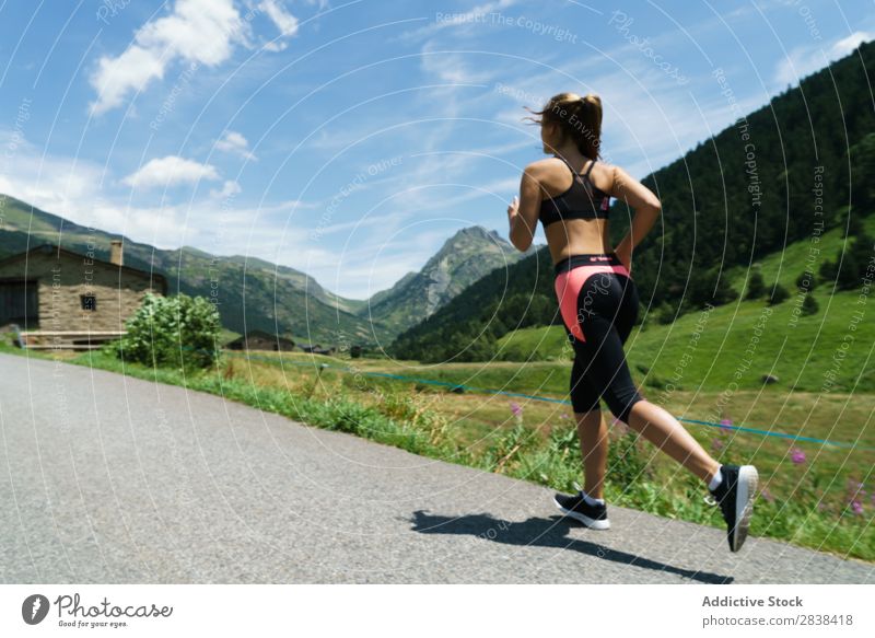 Frau beim Joggen auf dem Land Straße ländlich sportlich Jugendliche Fitness üben Athlet Sport Landschaft Training Freizeit & Hobby Aktion Sportbekleidung Gras