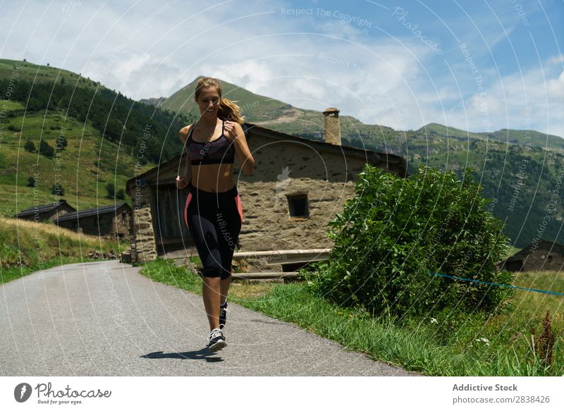 Frau beim Joggen auf dem Land Straße ländlich sportlich Jugendliche Fitness üben Athlet Sport Landschaft Training Freizeit & Hobby Aktion Sportbekleidung Gras