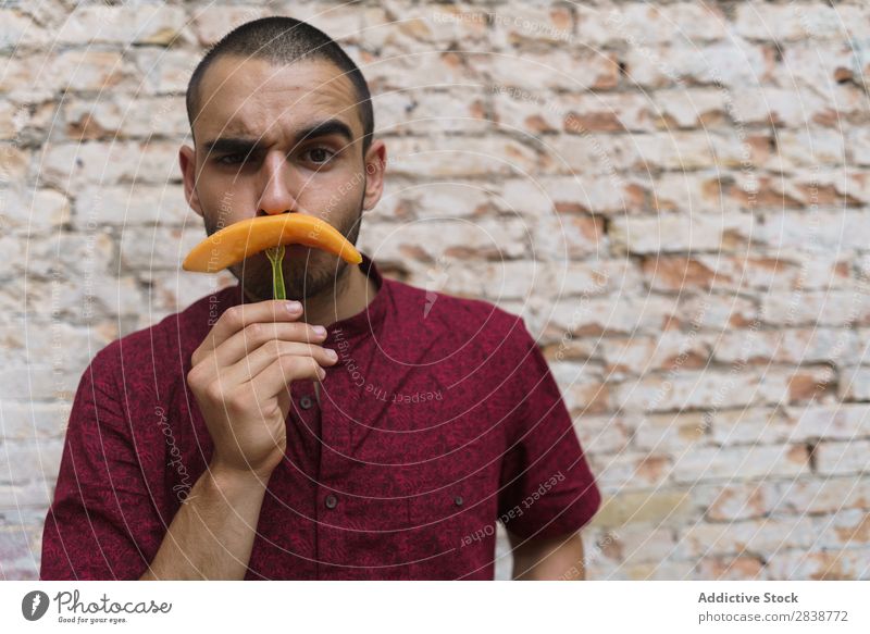 Verspielter Mann, der mit Früchten posiert. so tun, als ob spielerisch Oberlippenbart Spaß haben Frucht Nachbildung Körperhaltung Melonen Comic Humor Straße