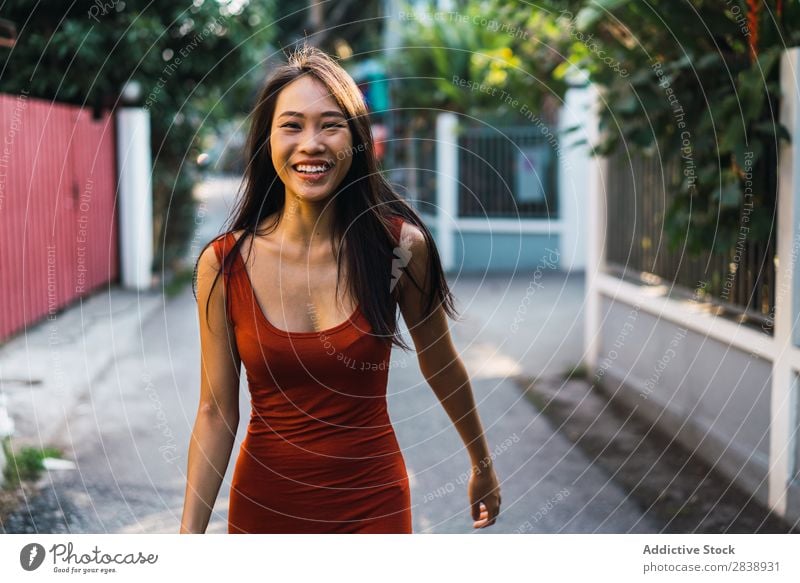 Fröhliche Frau, die auf der Straße posiert. hübsch asiatisch Jugendliche heiter Glück Freude grün Stadt schön Porträt attraktiv Beautyfotografie Mensch niedlich