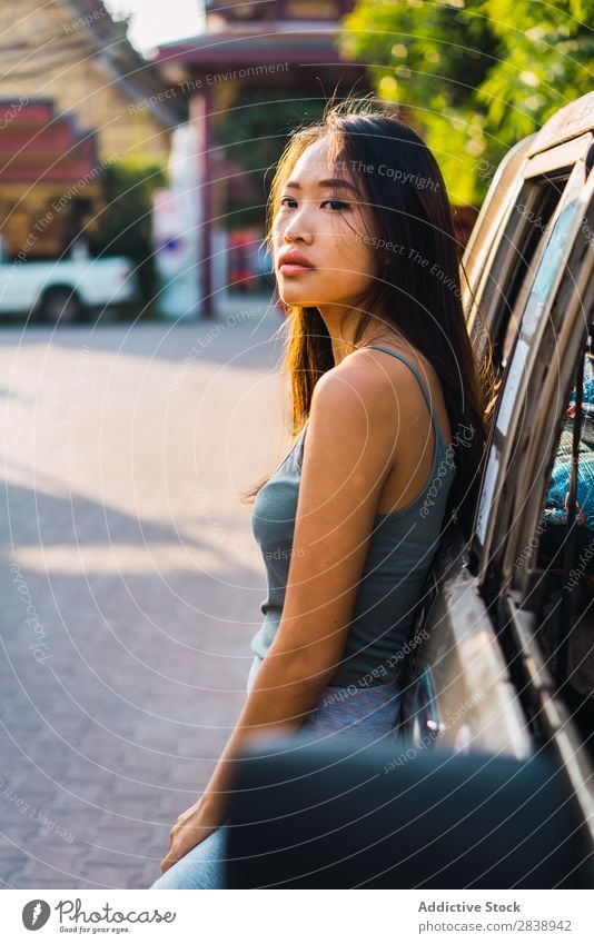 Asiatin, die sich auf das Auto stützt. Jugendliche Lifestyle schön Mädchen Fröhlichkeit Kaukasier Ferien & Urlaub & Reisen Erwachsene Fahrzeug PKW Frau frei