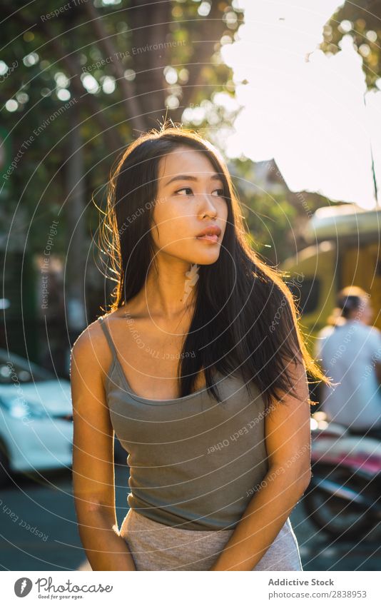 Fröhliche asiatische Frau, die auf der Straße posiert. hübsch Jugendliche heiter Freude Park Stadt brünett schön Porträt attraktiv Beautyfotografie Mensch