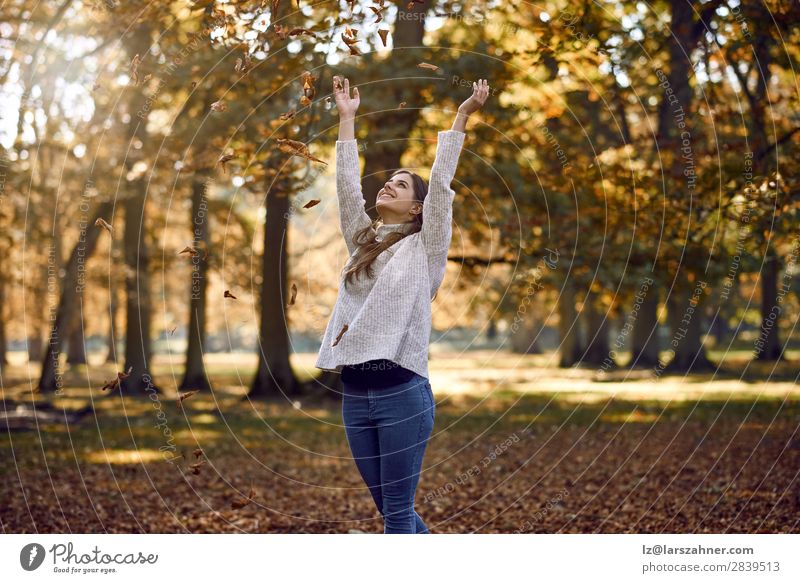 Fröhliche junge Frau, die Herbstblätter wirft. Freude Glück schön Erwachsene Familie & Verwandtschaft 1 Mensch 18-30 Jahre Jugendliche Natur Baum Blatt Park