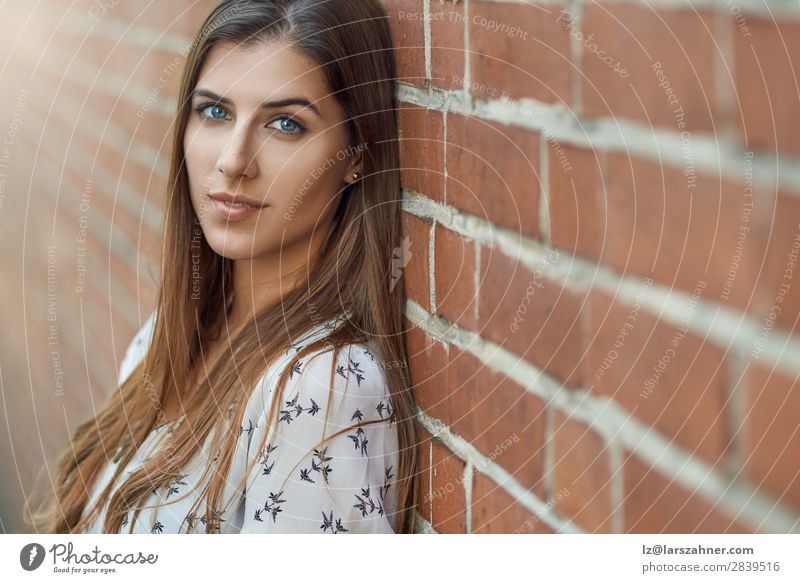Porträt einer jungen hübschen Frau an der Ziegelmauer Lifestyle Freude Glück schön Gesicht Erwachsene 1 Mensch 18-30 Jahre Jugendliche Natur Herbst Park Mode