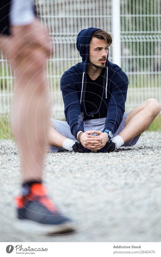 Zwei junge Männer, die sich nach dem Laufen auf der Straße ausstrecken. Aktion Erwachsene Athlet attraktiv Wesen Körper Fürsorge Kaukasier üben sportlich