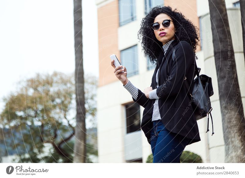 Schöne Frau, die ihr Handy auf der Straße benutzt. Mensch Jugendliche Telefon Freude Stadt Texten Internet urwüchsig Technik & Technologie Lächeln Glück