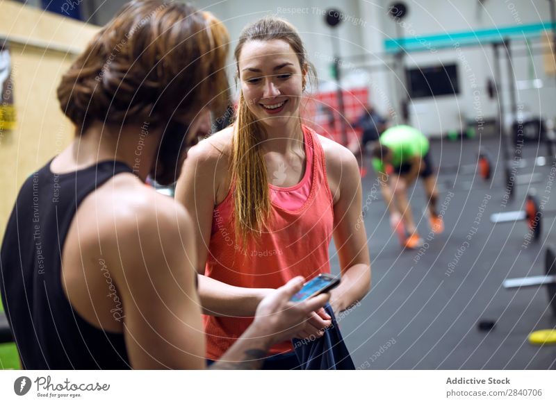 Fröhlich fröhliche Menschen mit Telefonen im Fitnessstudio Sporthalle Training sportlich üben Lifestyle PDA benutzend Browsen Gesundheit Sportbekleidung Aktion