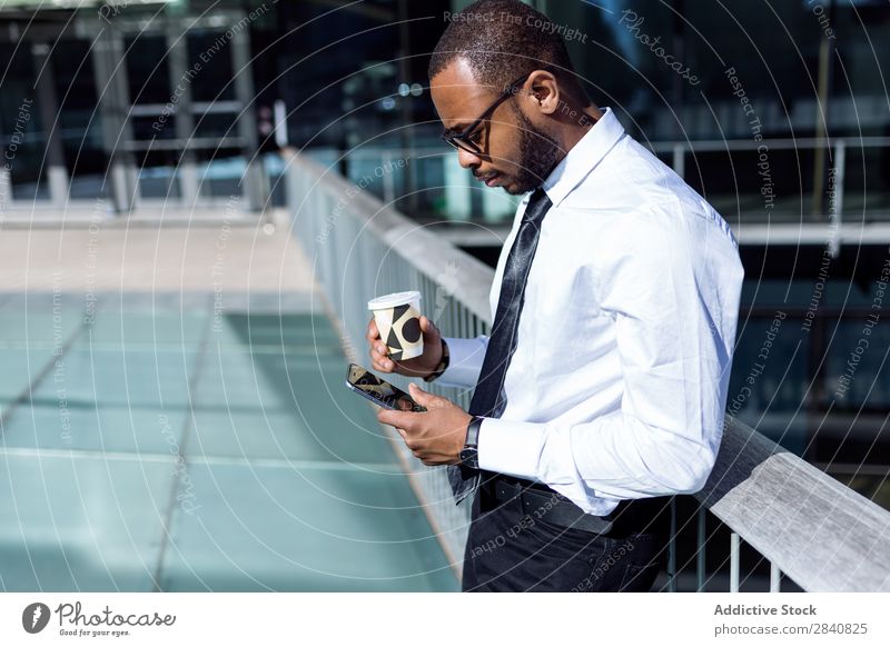 Junger Mann mit Kaffee und Telefon gelungen Stil selbstbewußt Geschäftsmann Technik & Technologie Morgen benutzend Browsen Geschäftsleute Afrikanisch schwarz