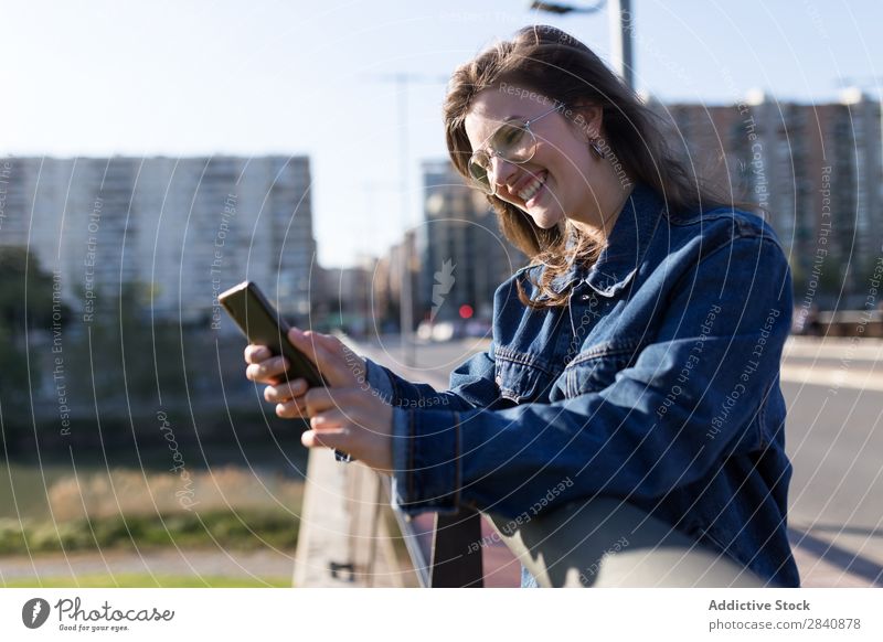 Lächelnde Frau auf der Straße mit Telefon laufen Überfahrt Stadt Sonnenbrille Glück Freude Mensch Großstadt Jugendliche Mädchen schön gehen Beautyfotografie
