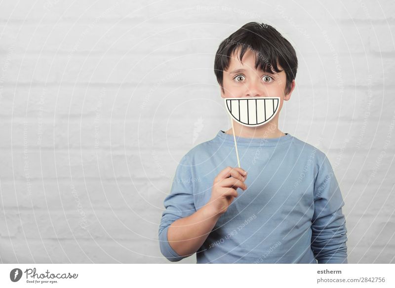 lustiges und lächelndes Kind mit einem Papplächeln Freude Spielen Mensch maskulin Kindheit Zähne 1 8-13 Jahre festhalten Fitness Lächeln lachen Freundlichkeit