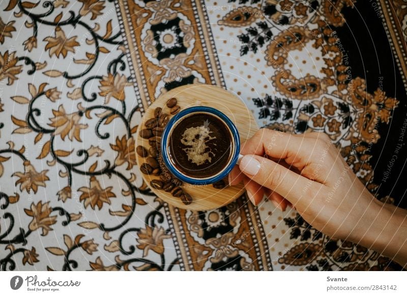 Frau hält Kaffeetasse auf floralem Muster fest Heißgetränk Kakao Latte Macchiato Espresso Tasse Becher Lifestyle Stil Design Mensch Junger Mann Jugendliche Hand