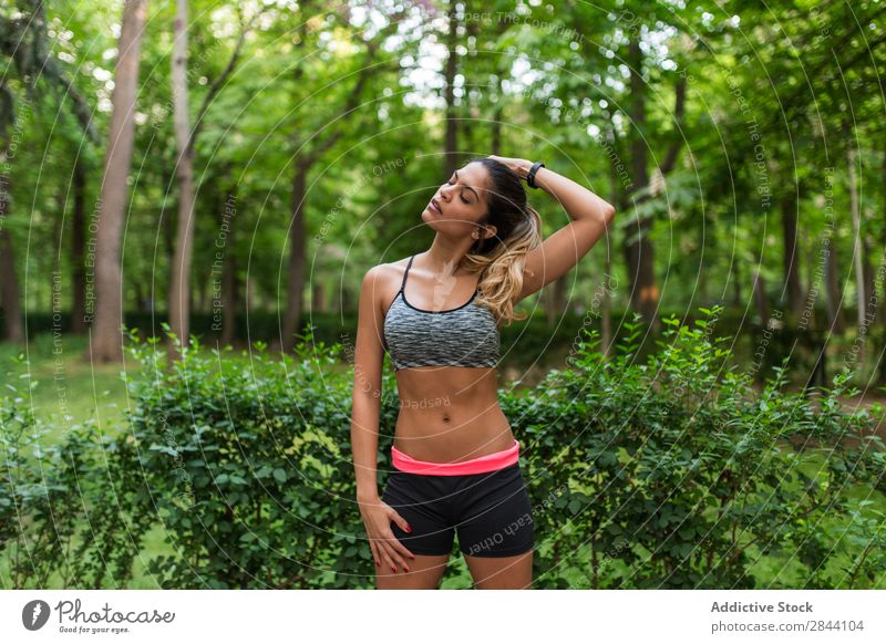Mädchentraining im Sommerpark Frau Training grün strecken Park Sportbekleidung Aktion beweglich Konzentration Dehnübung üben Inspiration Straße Sportlerin Stadt
