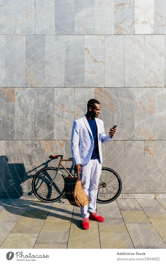 Stylischer schwarzer Mann mit Telefon draußen Stil Straße PDA elegant Körperhaltung trendy Business Anzug stilvoll Model Technik & Technologie Erfolg beobachten