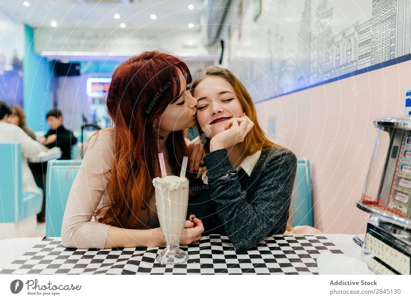 Fröhliche Frauen beim Cocktail hübsch Stadt Freundschaft Zusammensein sitzen trinken Milchshake heiter Lächeln Jugendliche schön Café attraktiv Dame Mode
