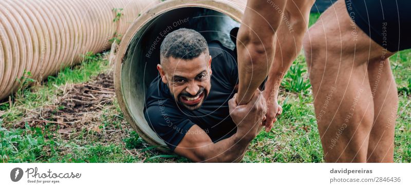 Mann in einem Hindernisparcours, der durch ein Rohr geht Sport Internet Mensch Erwachsene Tube stark schwarz anstrengen Konkurrenz Teamwork Anstrengung Grimasse