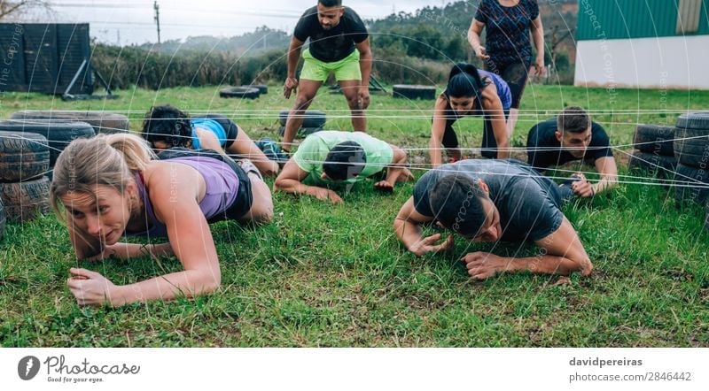 Teilnehmer des Hindernislaufs krabbeln unter Stromkabeln Sport Mensch Frau Erwachsene Mann Menschengruppe Wiese genießen schwarz anstrengen Konkurrenz