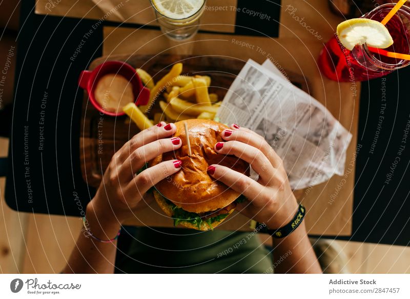 Getreidefrau beim Pflücken eines Hamburgers Burger Fries Fastfood Lebensmittel frisch Fleisch Mahlzeit ungesund Snack Belegtes Brot Geschwindigkeit Brötchen
