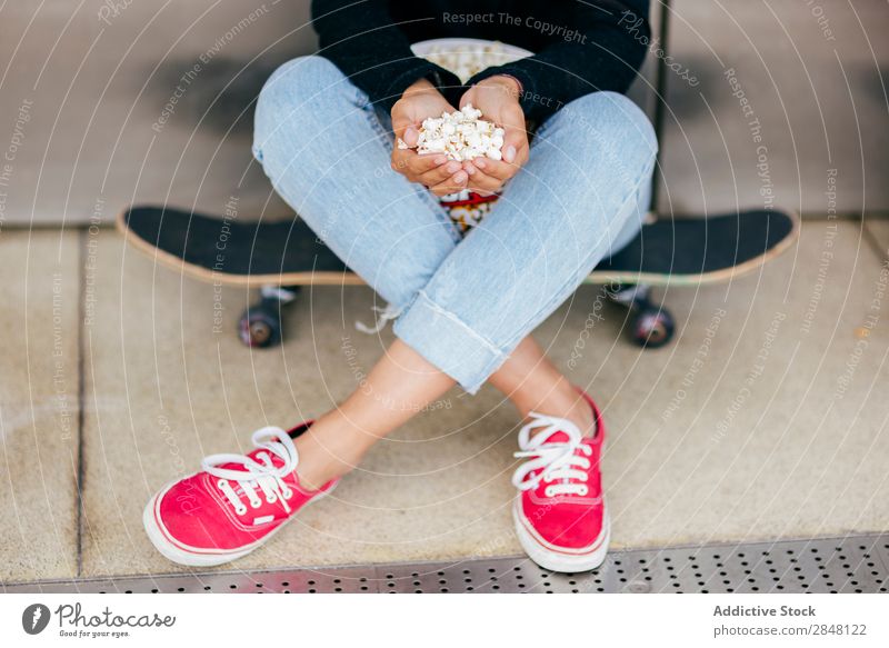 Getreide Frau mit Haufen Popcorn Popkorn Skateboard Stadt Anhäufung Jugendliche Snack Stil Halt Bekleidung Schickimicki Eimer Kultur sitzen Körperhaltung