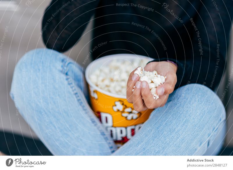 Crop Mädchen mit Popcorn in der Hand Frau Popkorn Stadt Anhäufung Jugendliche Snack Stil Halt Bekleidung Schickimicki sitzen Eimer Kultur Selbstständigkeit