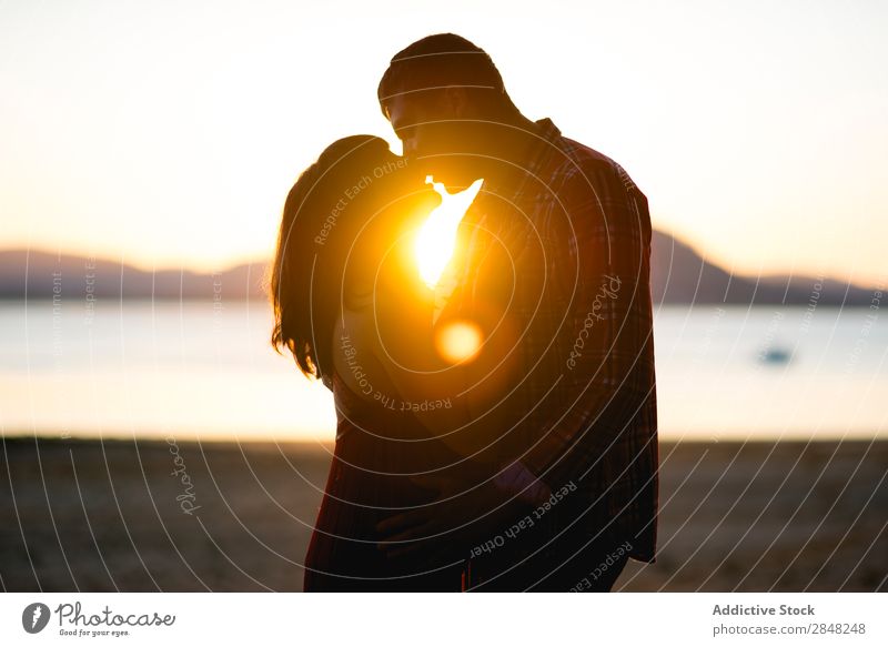 Ein Paar küsst sich bei Sonnenuntergang. Silhouette See Küssen Liebe Natur Frau Mann Glück Fröhlichkeit Mensch Romantik schön romantisch Partnerschaft