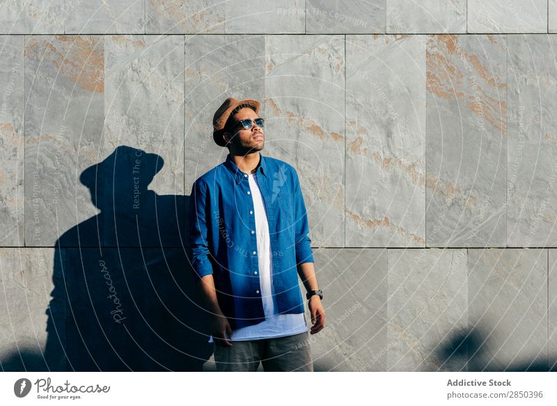 Mann mit Hut, der in der Wand posiert. Großstadt stehen Mensch Stadt Erwachsene modern Lifestyle Einsamkeit Porträt modisch Mode elegant Sonnenstrahlen