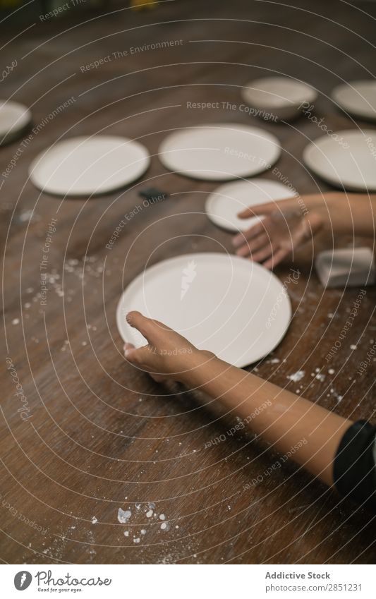 Getreideperson, die mit der Keramikplatte arbeitet. Mensch Werkstatt Teller Geschirr Handarbeit Schreibtisch machen Ton Utensil Kunst Emaille Kreativität
