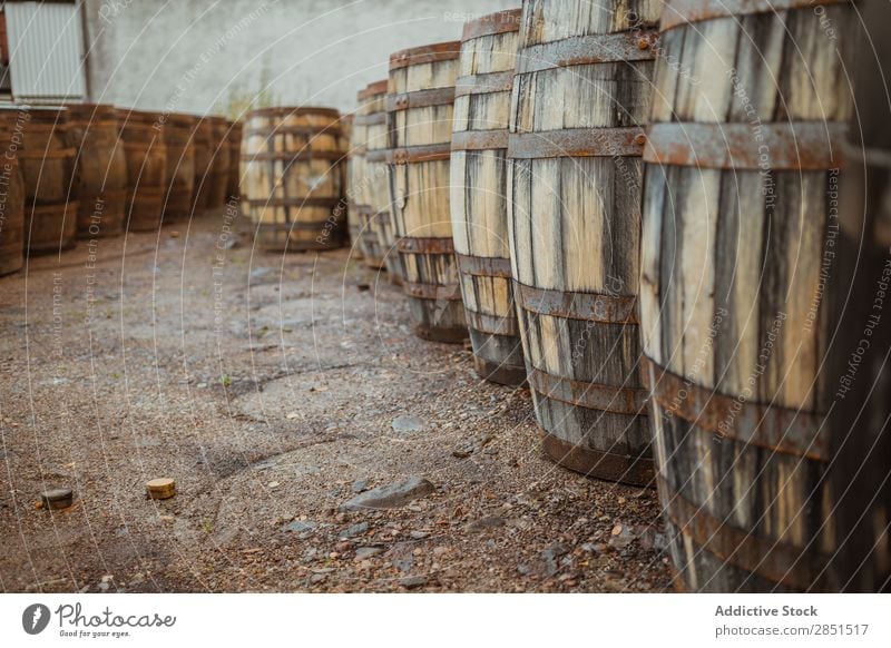 Holzfässer auf Steinoberfläche Fässer arrangiert Weingut Lager Produktion Fabrik Lagerhalle Alkohol Getränk Stapel Sammlung rustikal Ordnung Straßenbelag