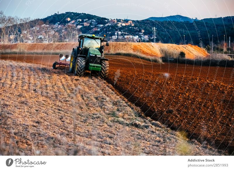Traktor beim Pflügen des Feldes pflügen Erde Bauernhof Landschaft Ackerbau landwirtschaftlich Landen Pflug Landwirtschaft Bodenbearbeitung Gerät braun Maschine