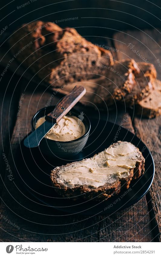 Rustikales Brot mit Butter backen Bäckerei Kohlenhydrat dunkel Mehl Lebensmittel frisch selbstgebacken Brotlaib Stimmung rustikal Aufstrich Weizen Holz